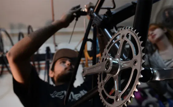 Mecánico de Una Velocidad ajustando la transmisión de una bicicleta